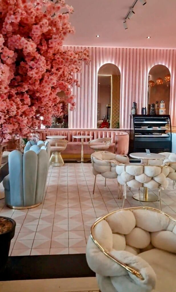 Chic, blush-pink interior of The Super Taste dessert cafe, showcasing plush textured seating and a refined, feminine aesthetic