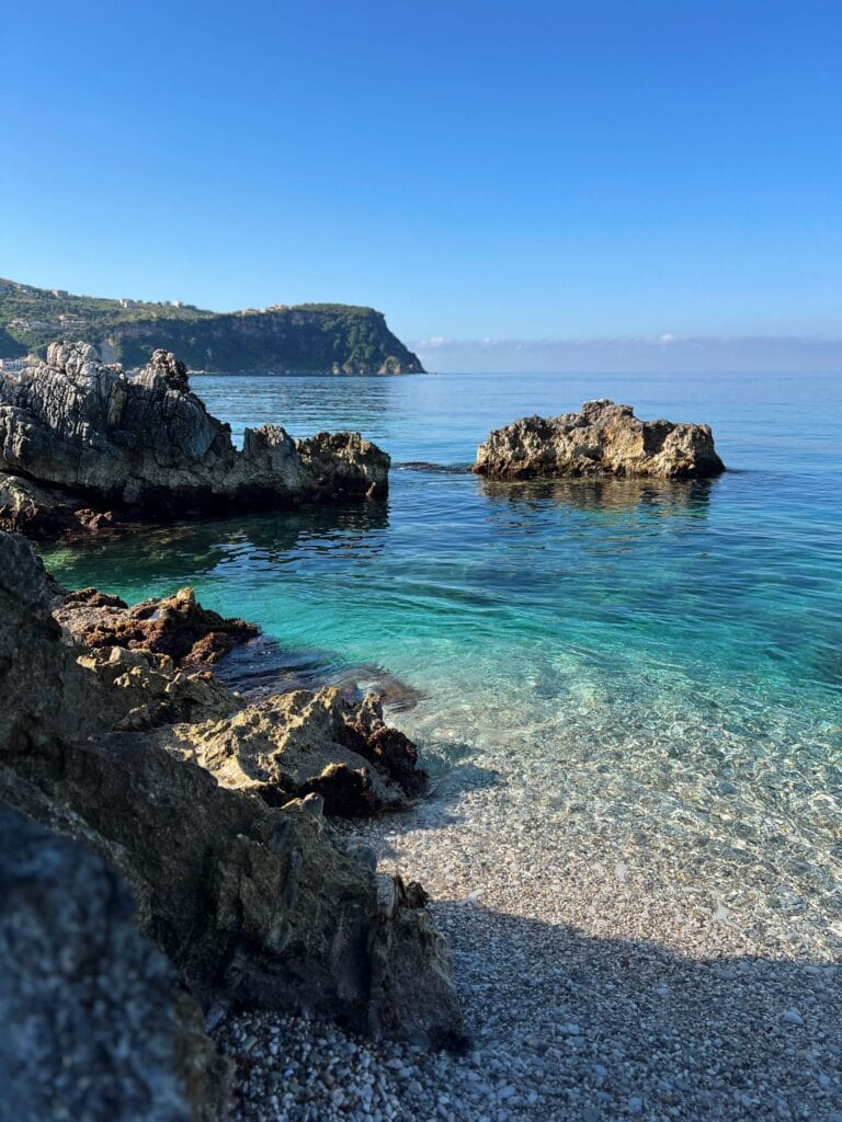 Crystal clear waters and an empty beach with big rocks in albania