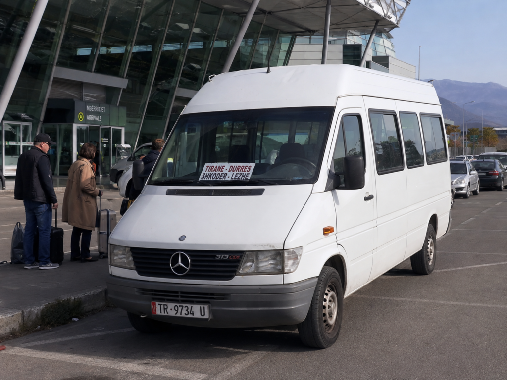 White Albanian furgon minibus waiting outside an airport terminal