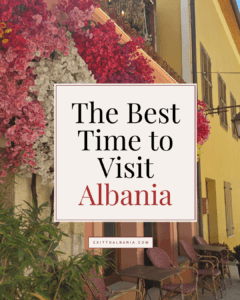 The Best Time to Visit Albania title graphic overlaying a scenic street view of a yellow building adorned with vibrant pink and white floral displays and outdoor cafe seating.